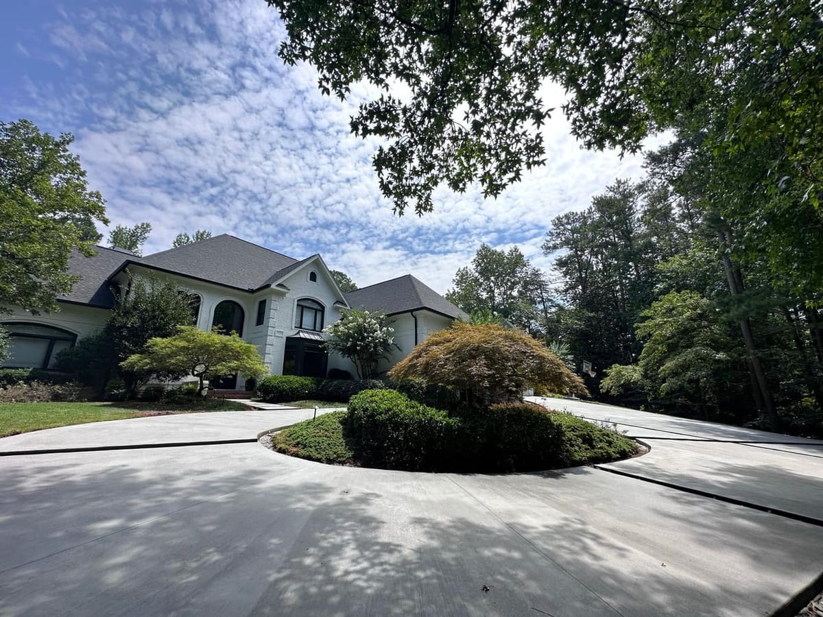 Poured concrete circular driveway curving around a planted island at a two story home, Atlanta, Georgia
