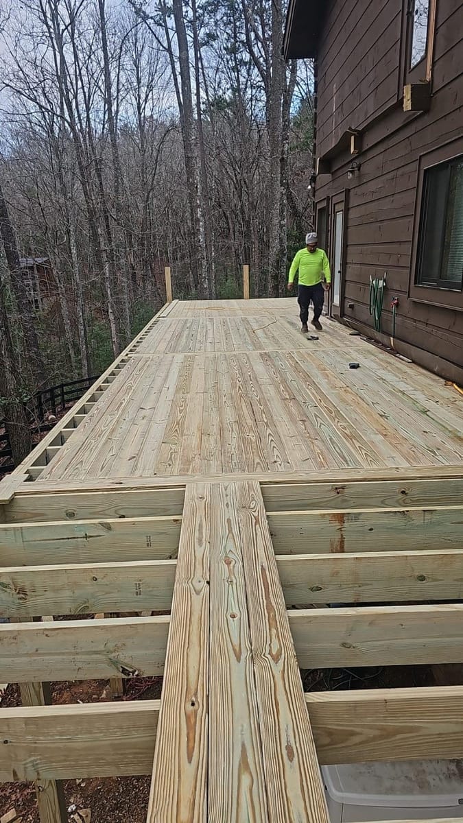 Wraparound deck built around a timber cabin, with beam work and footings cut into the hillside, Blue Ridge, Georgia