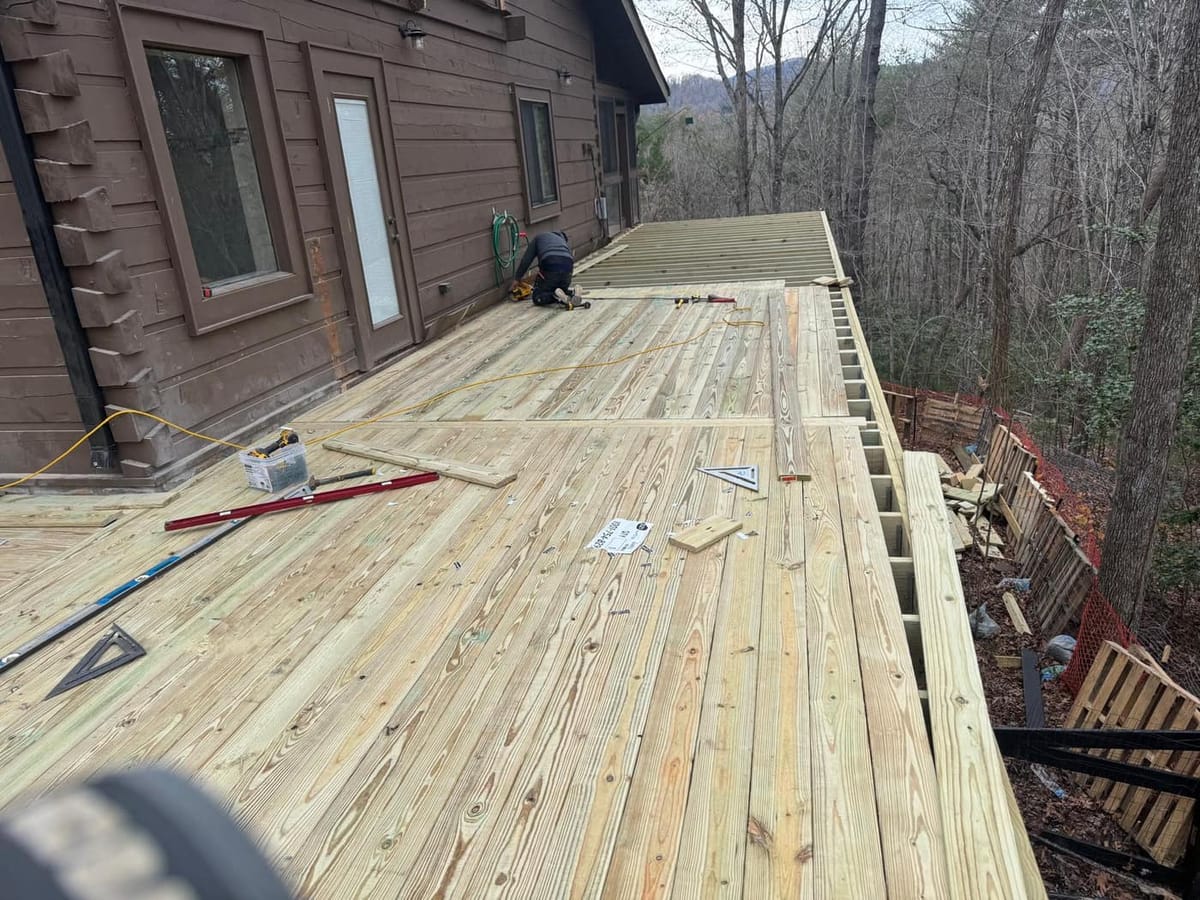 Wraparound deck built around a timber cabin, with beam work and footings cut into the hillside, Blue Ridge, Georgia