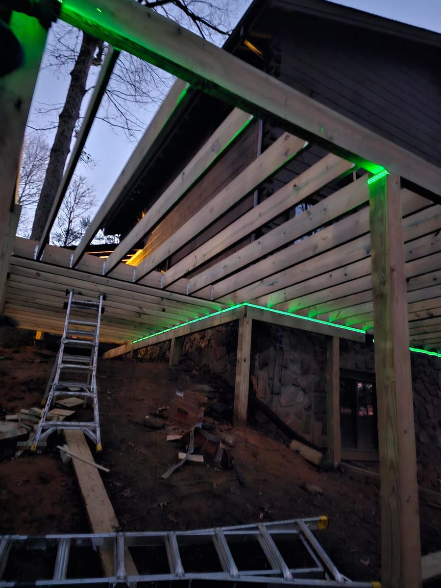 Wraparound deck built around a timber cabin, with beam work and footings cut into the hillside, Blue Ridge, Georgia