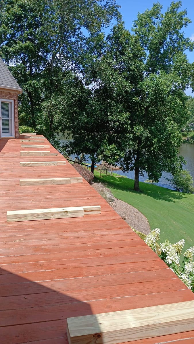 New timber railing installed along a long stained deck overlooking open water, Cartersville, Georgia