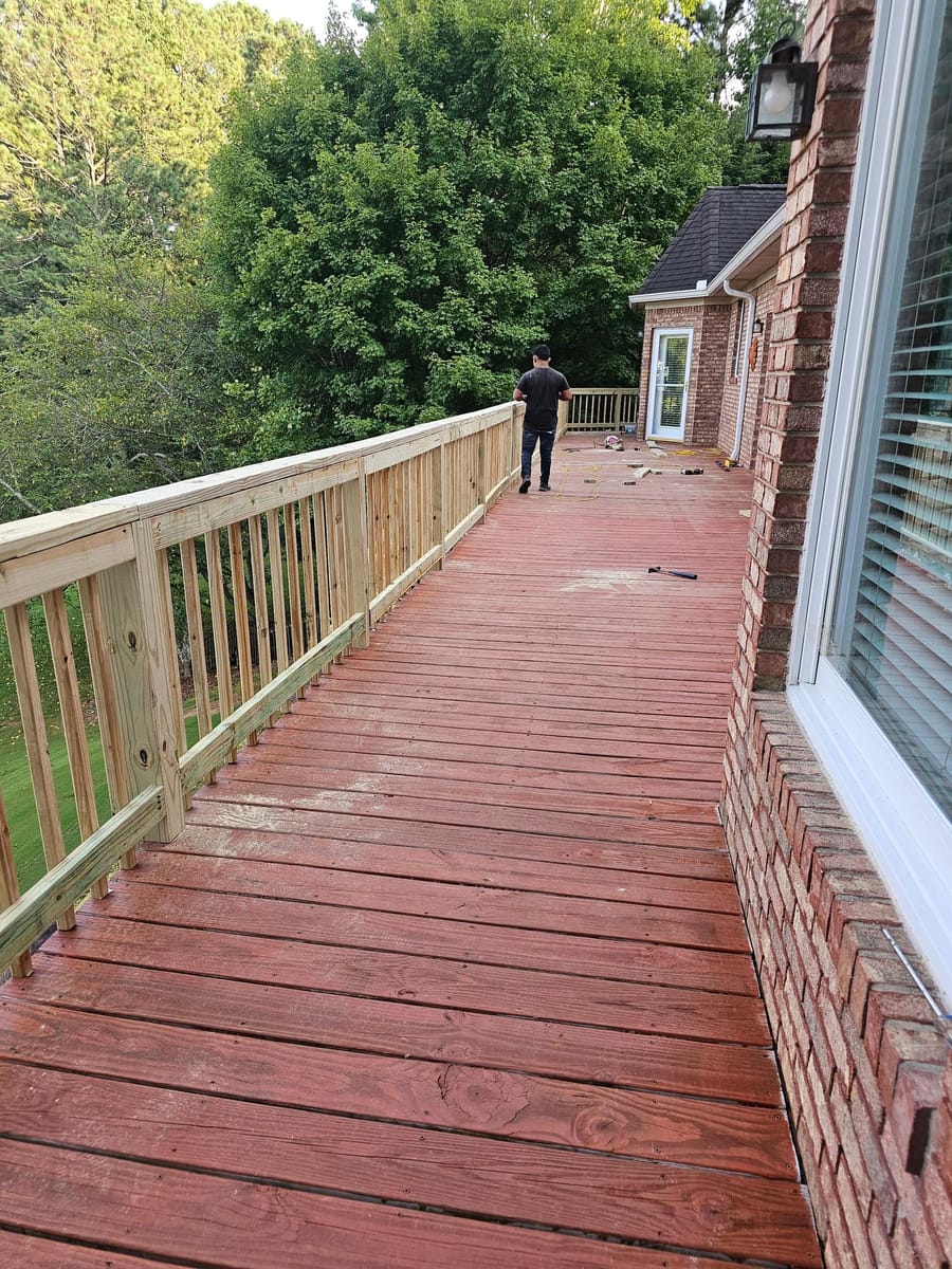 New timber railing installed along a long stained deck overlooking open water, Cartersville, Georgia