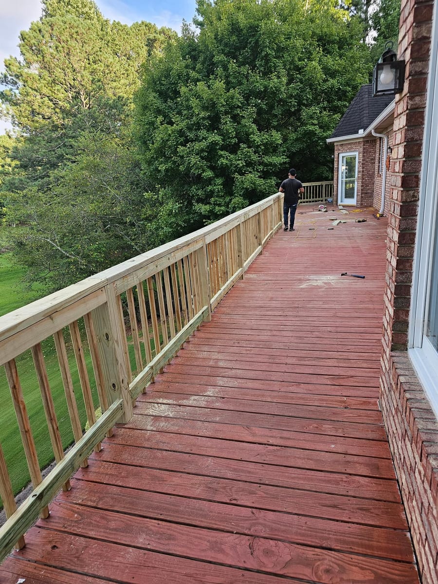 New timber railing installed along a long stained deck overlooking open water, Cartersville, Georgia