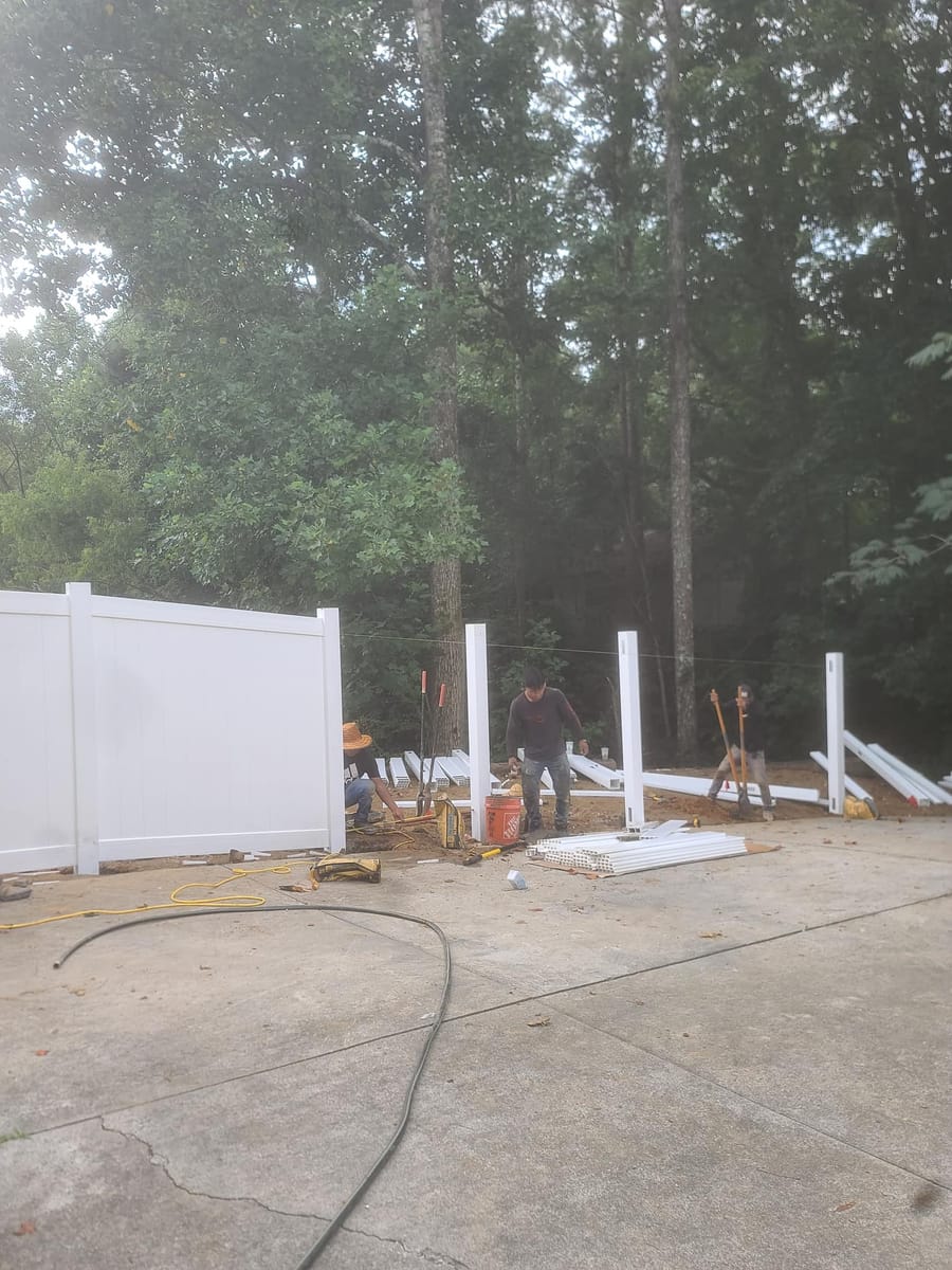 White vinyl privacy fence with braced gate, enclosing a wooded rear garden, Dalton, Georgia