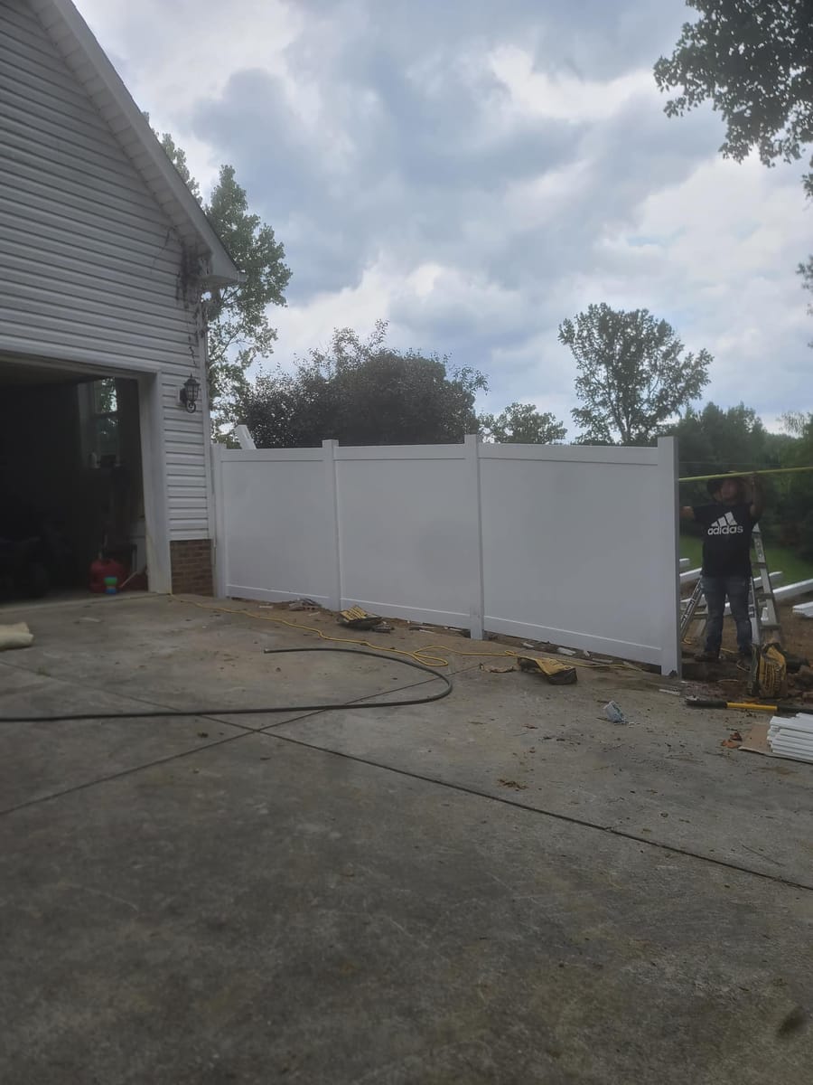 White vinyl privacy fence with braced gate, enclosing a wooded rear garden, Dalton, Georgia