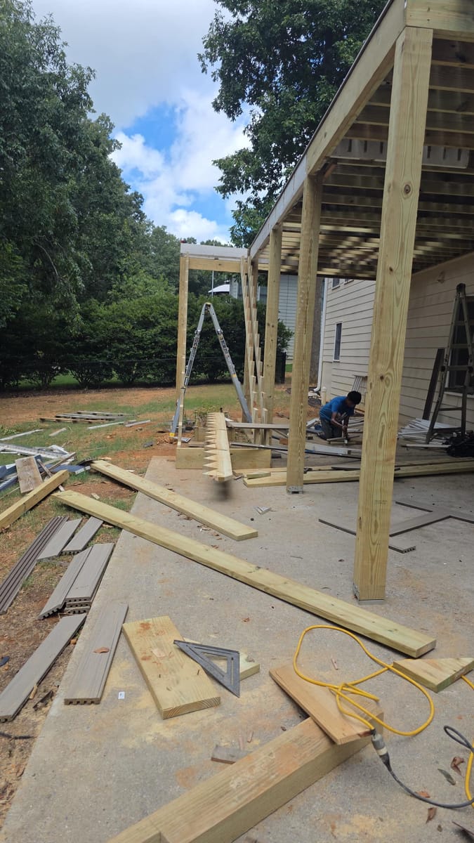 Weathered boards replaced with gray Trex composite decking on the existing frame beneath a covered deck, Kingston, Georgia
