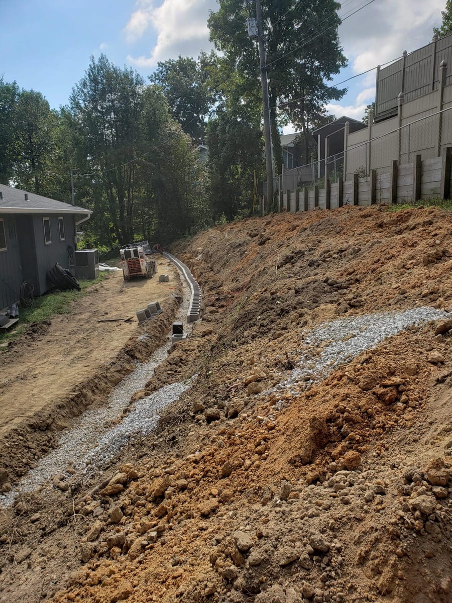 Excavated slope with drainage trench and gravel base, Marietta, Georgia