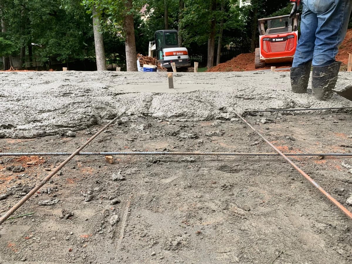 Wire mesh reinforcement and plate compactor during prep, Marietta, Georgia