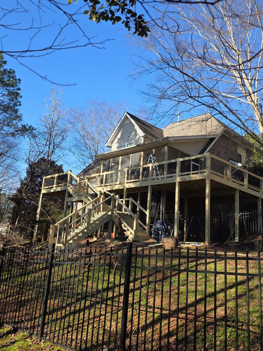 New elevated deck and screened porch on a brick home, with a pergola structure at grade below, McDonough, Georgia
