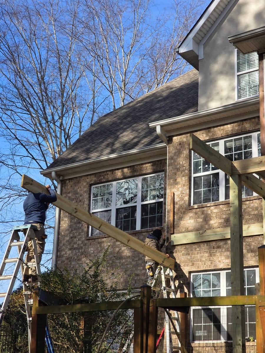 New elevated deck and screened porch on a brick home, with a pergola structure at grade below, McDonough, Georgia