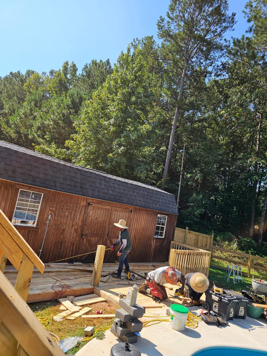 Timber pool deck framed and boarded around an above-ground pool beside a barn, Rome, Georgia