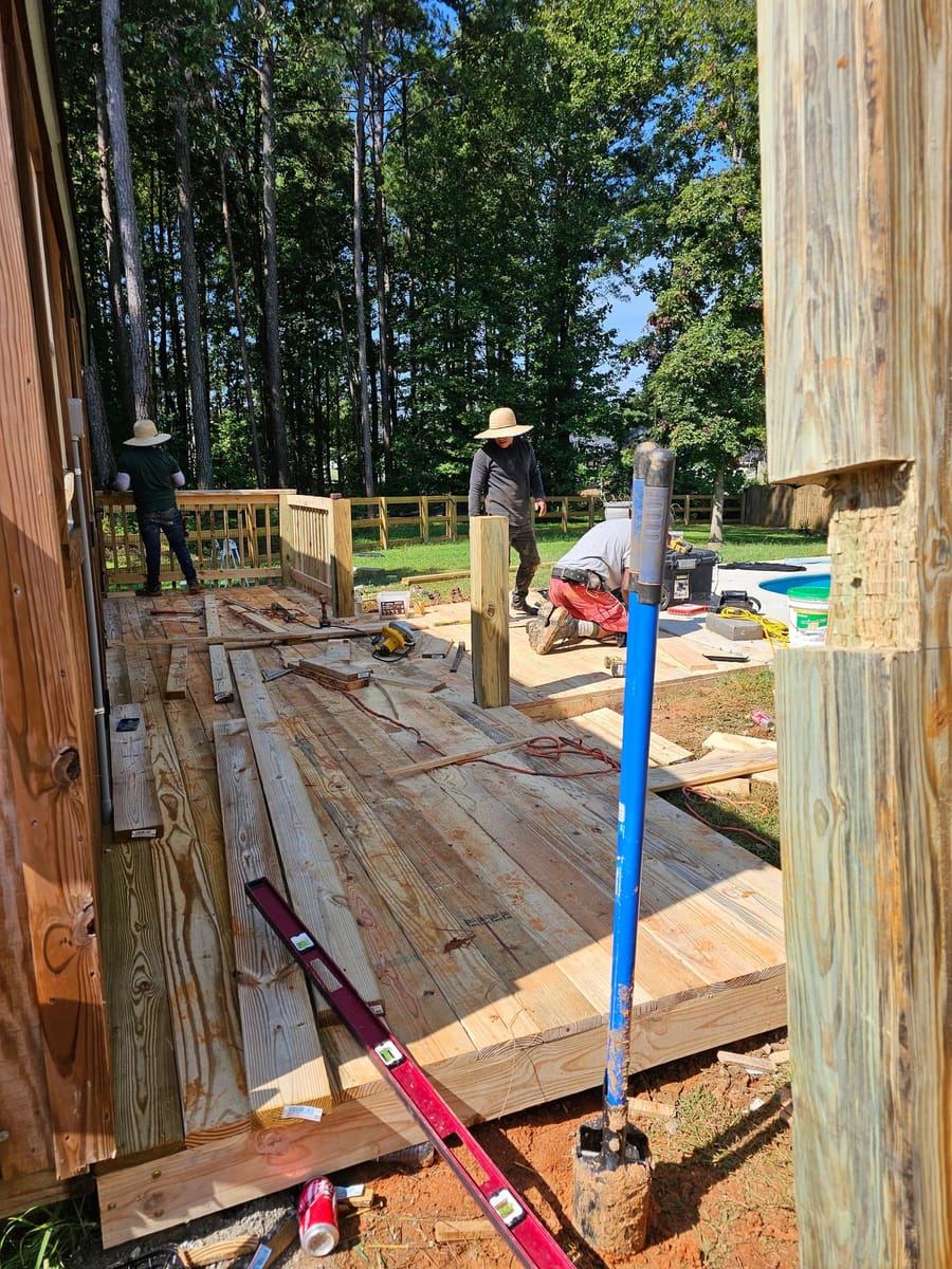 Timber pool deck framed and boarded around an above-ground pool beside a barn, Rome, Georgia