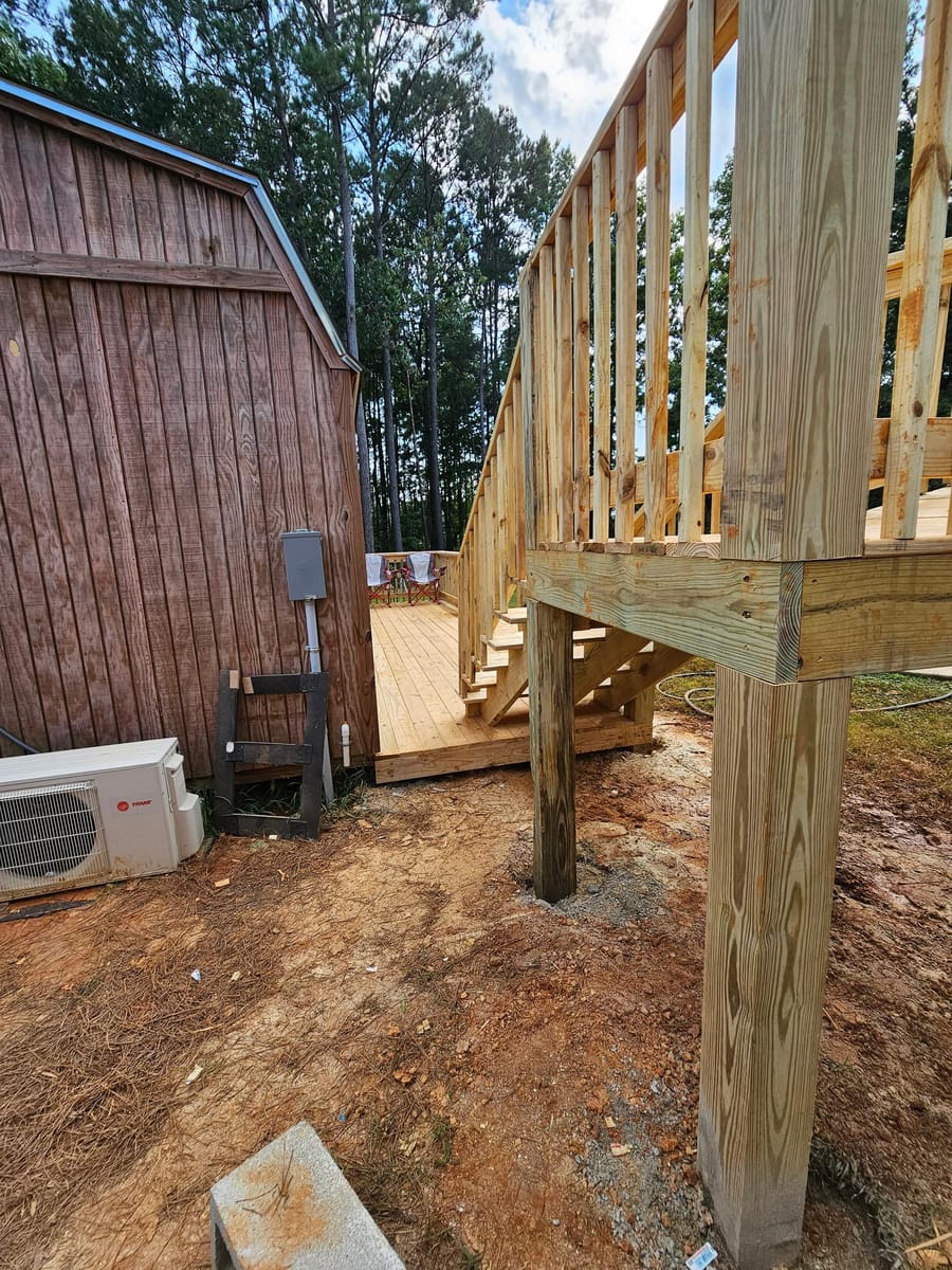Timber pool deck framed and boarded around an above-ground pool beside a barn, Rome, Georgia