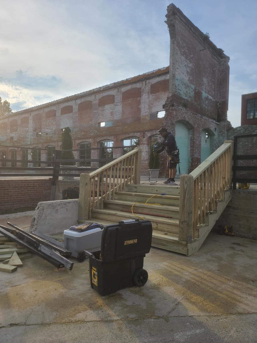 New timber stair and handrail run built against a historic brick mill building, Rome, Georgia