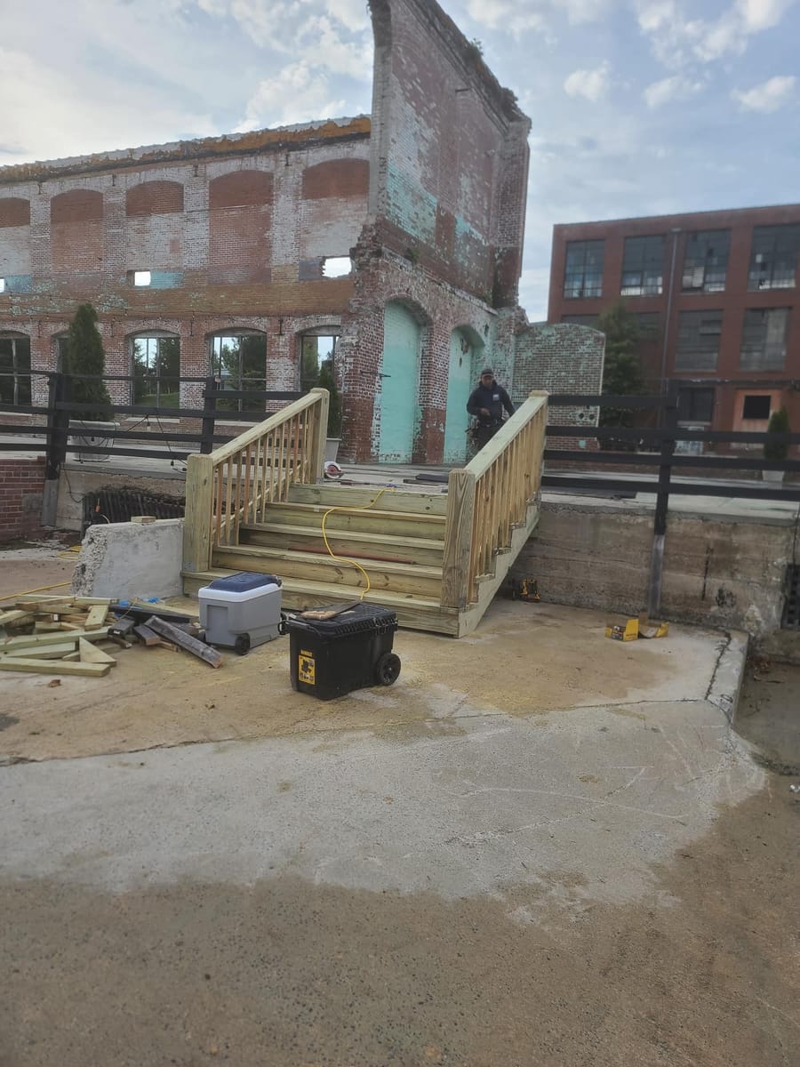 New timber stair and handrail run built against a historic brick mill building, Rome, Georgia