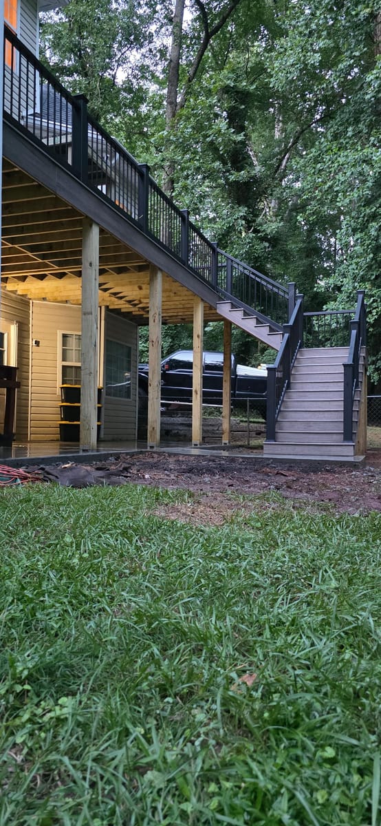 Deck rebuilt in Trex with black metal railings, over a poured concrete landing at the foot of the stairs, Stockbridge, Georgia